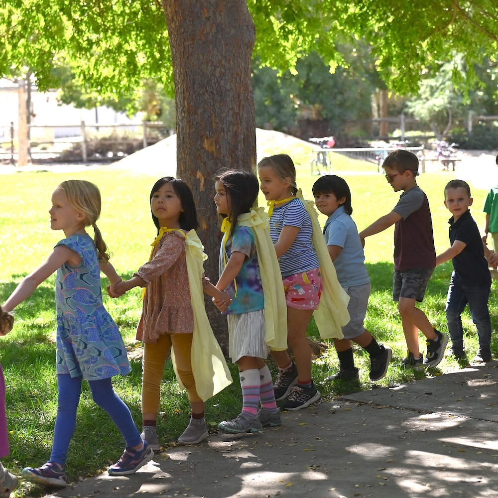 Kindergarten class in line holding hands outside in yard