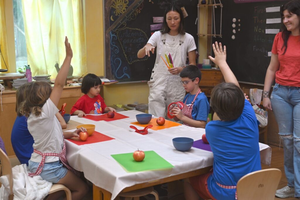 Teacher instructing students with several students' hands raised